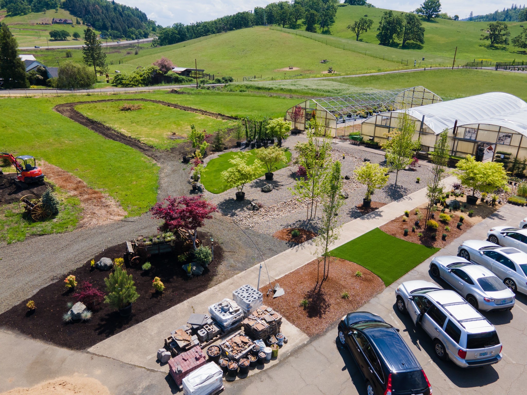 Aerial dusk view of a completed front-yard xeriscape with gravel, turf accents and lighting